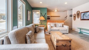 A cozy living room with two sofas, a wooden coffee table, and a lamp.