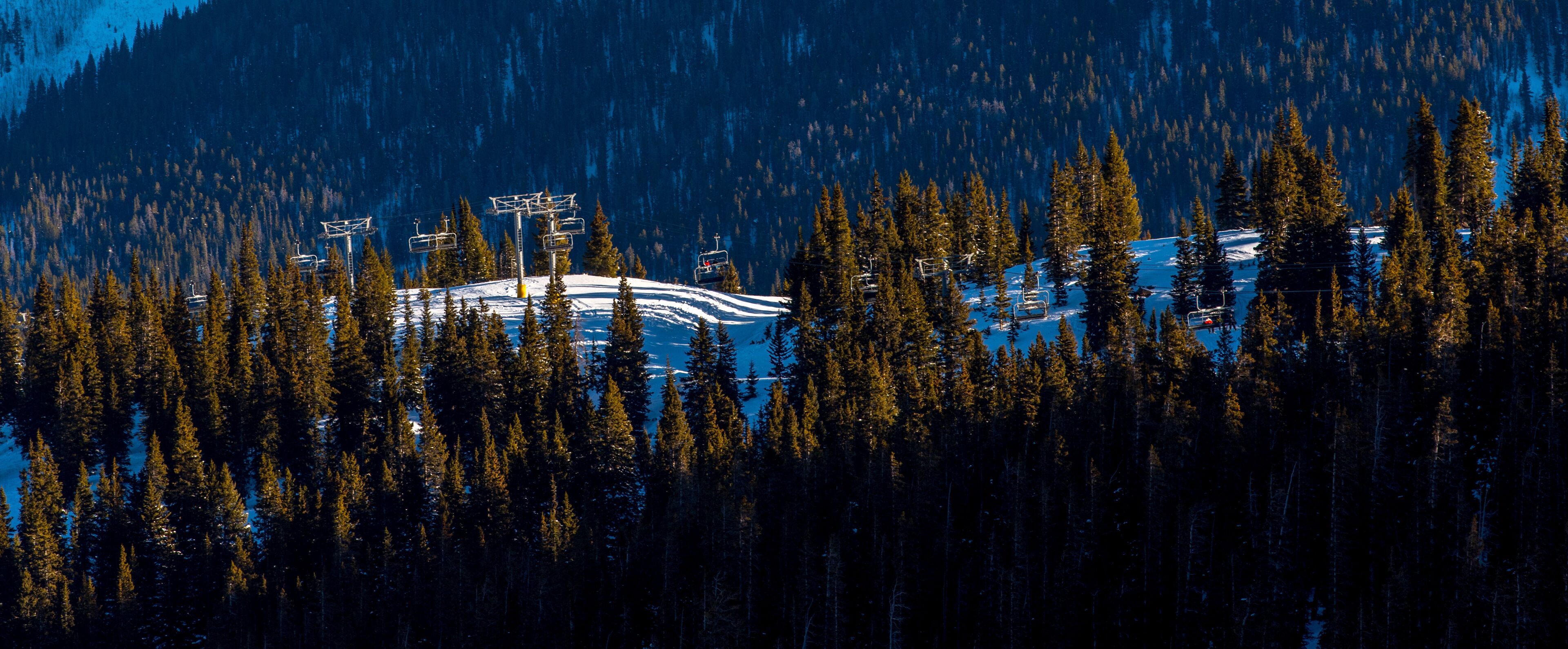 Une station de ski dotée de télésièges et offrant une vue imprenable sur une montagne enneigée.