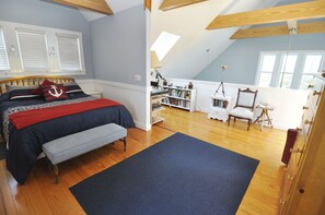 A bedroom with a bed, a bench, a bookshelf, and a desk. - Aleta:  Pet friendly, waterfront, perfect for two. Private docking. (Ocracoke)