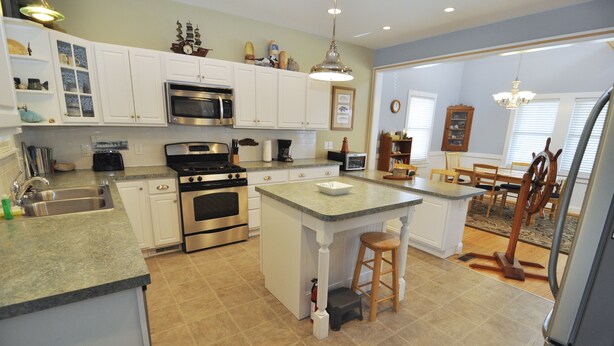 A kitchen with white cabinets, a stainless steel stove, and a granite countertop. - Aleta:  Pet friendly, waterfront, perfect for two. Private docking. (Ocracoke)