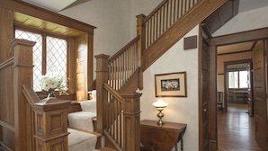 A wooden staircase with a cushioned landing, a framed picture on the wall, and a vase with flowers on the landing. - Lakefront Home in the Heart of Aurora, Sunset Ready! (Aurora)