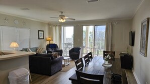 Ein geräumiger Wohnbereich mit Esstisch, Sofas und einem Balkon mit Blick.
