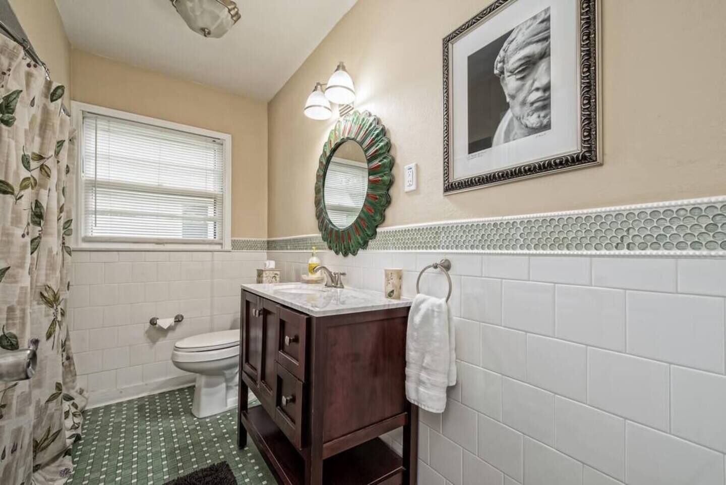 A bathroom with a toilet, sink, and shower curtain.