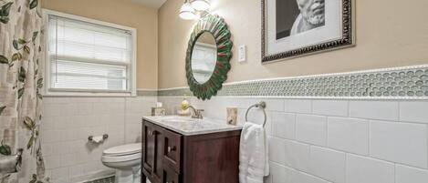 A bathroom with a toilet, sink, and shower curtain.