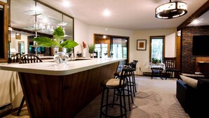 Une cuisine moderne dotée d’un îlot central, de tabourets de bar et d’un grand miroir.