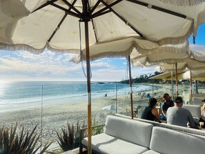A beachside seating area with a view of the ocean and beach.