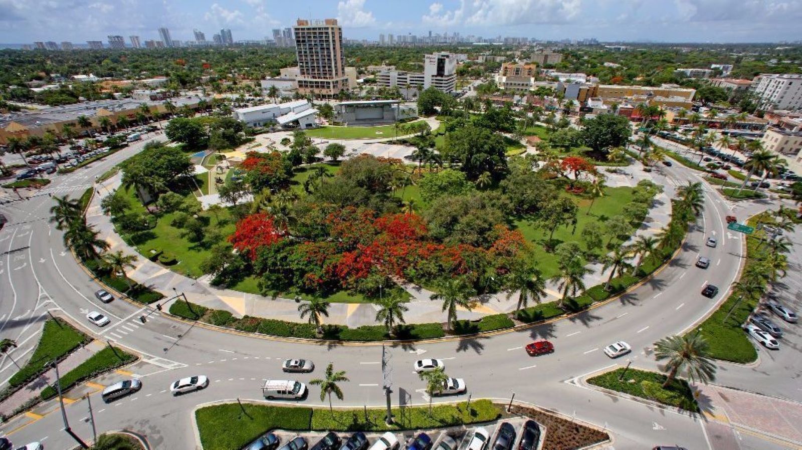 A circular road with surrounding greenery and buildings.