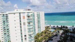 A high-rise hotel with multiple balconies overlooking a beach and ocean.