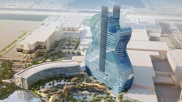 A modern hotel with a curved glass facade, a central atrium, and a landscaped pool area.