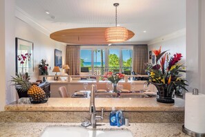 A modern kitchen with a granite countertop, a sink, and a hanging light fixture.