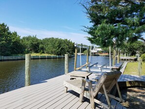 A wooden dock with benches and a small boat docked.