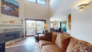 A spacious living area with a fireplace, a dining table, and a sofa. - Summit Condo 2815 - Sweet Penthouse with Great Views (Elkhorn)