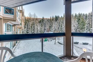 Un balcon donnant sur une forêt enneigée.