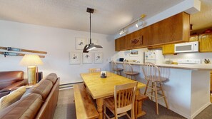 A compact living space with a dining area, kitchenette, and seating area.