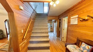 Un escalier en bois, dont les marches sont recouvertes de moquette, mène au deuxième étage.