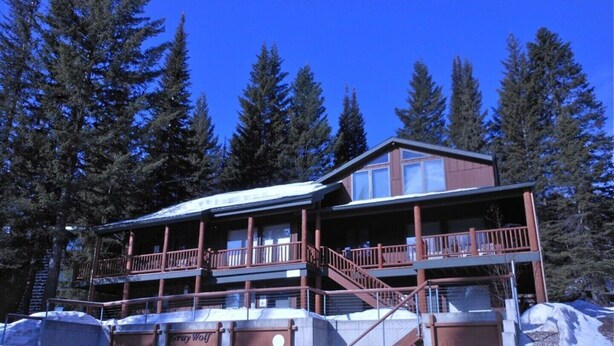 A two-story lodge with a balcony and a staircase leading to the upper level.