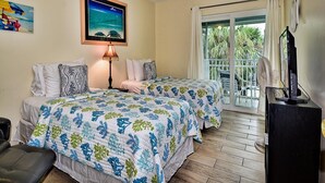 Habitación de hotel con dos camas, un balcón con vistas a palmeras, un cuadro de una playa y un televisor sobre un mueble.