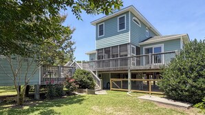 A two-story house with a covered patio and a fenced backyard. - Follow The Heron: Fantastic home with lots of decks. (Ocracoke)