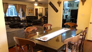Un coin repas avec une table à plateau en verre, des chaises en bois et un set de table.