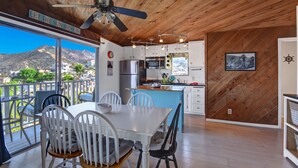 A modern kitchen with white cabinets, a blue island, and a view of mountains. - Cozy 2 Bedroom Home with GOLF CART, Stunning View, Balcony, Grill, Wifi - 124 Hi (Avalon)