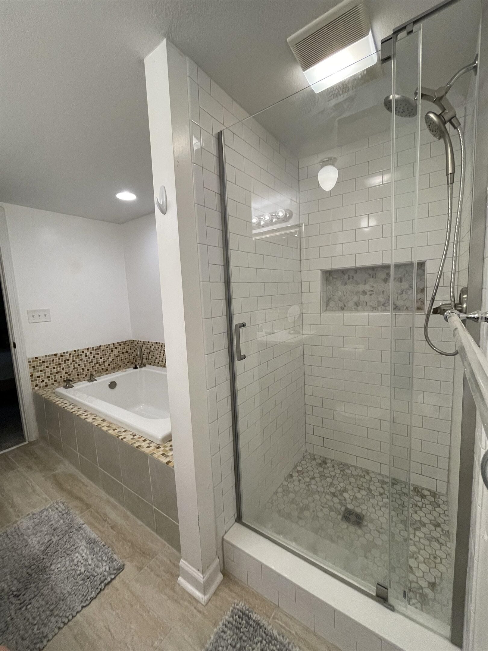 Een bad/douchecombinatie, een bubbelbad, een haardroger, handdoeken