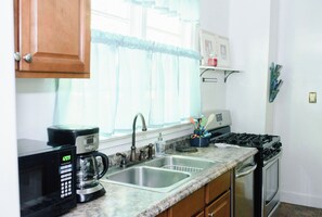 Une cuisine équipée d’une machine à café, d’un évier, d’une cuisinière et de placards.