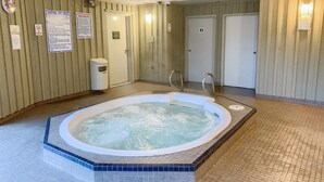 Un espacio de spa con hidromasaje, paneles de madera y suelo de baldosas.