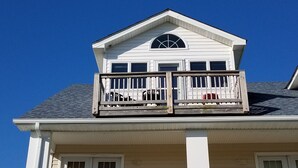 Une maison à deux étages avec un balcon.