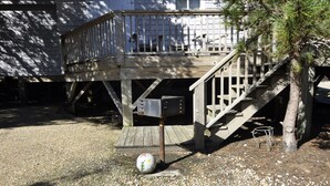Une terrasse en bois avec une boîte aux lettres et un support pour boîte aux lettres.