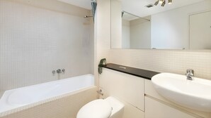 Un baño moderno con una bañera, un inodoro y un lavabo.
