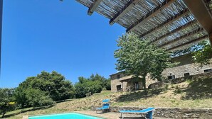 A stone building with a pool, two blue sun loungers, and a tree. - Beautifully converted farmhouse alone on a tuscan hillside with stunning views (Cortona)