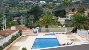 A rooftop pool with a view of a hillside residential area. - F9 Large bright apartment, 3 rooms, beach at 50m, swimming pool and sea view  (Théoule Sur Mer)
