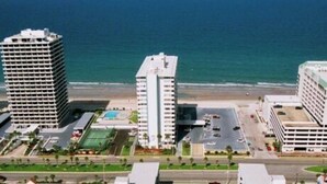 A high-rise hotel with multiple floors, a parking lot, and a view of the ocean. - Spacious, updated 1 bed/1 bath condo with gorgeous ocean views (Daytona Beach)