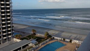 A hotel with a pool, beach view, and a high-rise building in the background. - Spacious, updated 1 bed/1 bath condo with gorgeous ocean views (Daytona Beach)