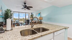 A modern kitchen with granite countertops, a double sink, and a dishwasher.