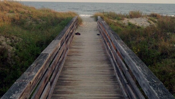 A wooden boardwalk leading to the beach, surrounded by dunes and vegetation. - Shell House  - Less than a block to beach access and recently updated! (Sunset Beach)