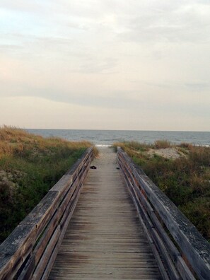 A wooden boardwalk leading to the beach, surrounded by dunes and vegetation. - Shell House  - Less than a block to beach access and recently updated! (Sunset Beach)