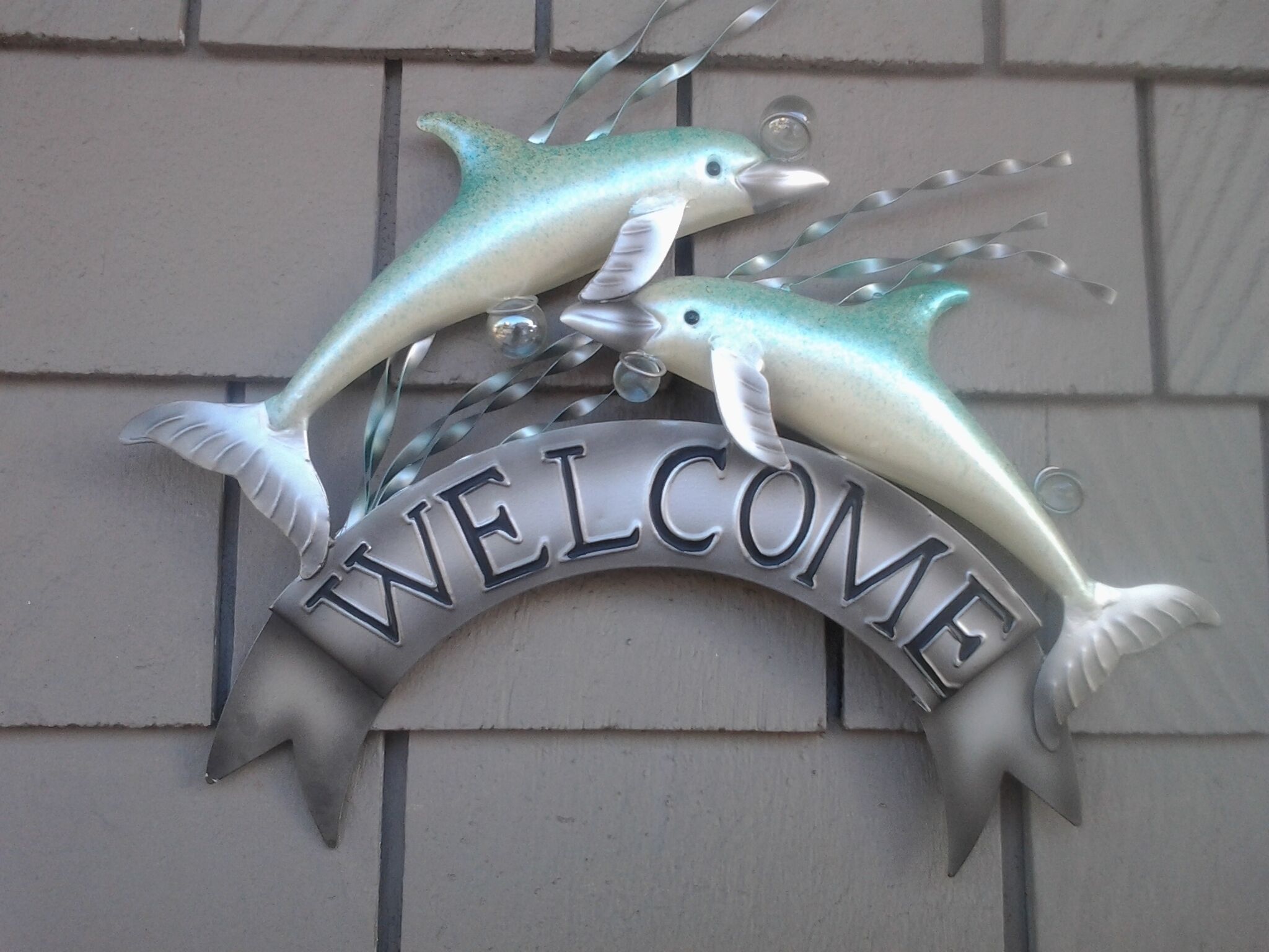A welcome sign with two fish figures above it.