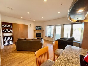 Una sala de estar con sofá, sillas, chimenea y televisión.