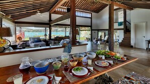 Un comedor amplio con una mesa de madera dispuesta para una comida, con vistas a un paisaje pintoresco.