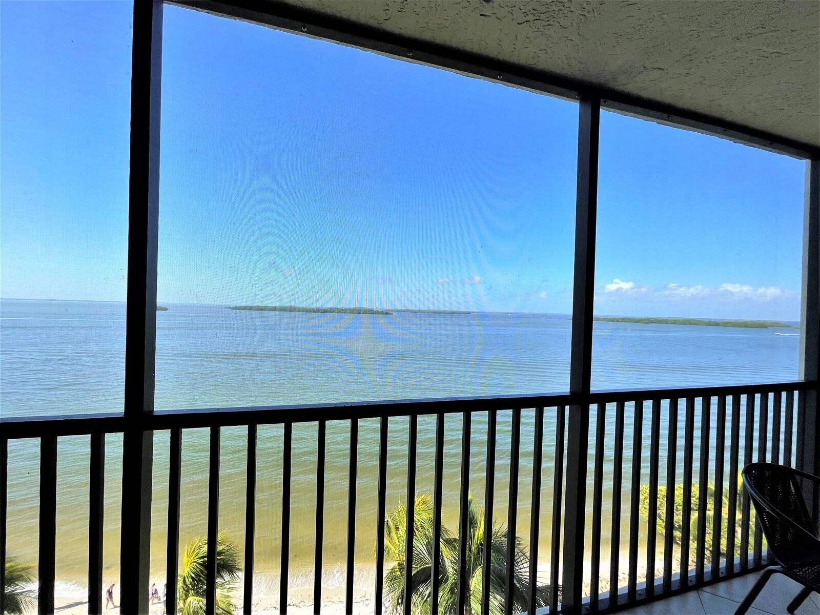 A balcony with a view of a beach and ocean.