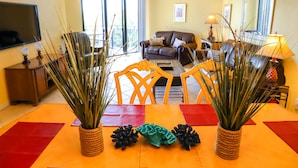 A dining area with a table set for four, surrounded by chairs, and two potted plants. - Key West Beachfront Luxury 2/2 Condo A212   (Key West)
