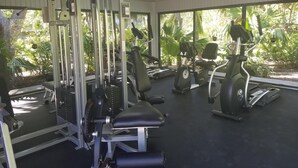 A gym with various exercise equipment, including a squat rack, bench press, and cardio machines. - Key West Beachfront Luxury 2/2 Condo A212   (Key West)