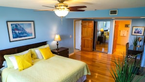 A bedroom with a bed, bedside table, lamp, and a potted plant. - Key West Beachfront Luxury 2/2 Condo A212   (Key West)