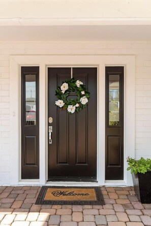 A dark brown front door with a white-framed window on the left and a doorbell above it. - Pool House Scottsdale | Play Starts Here! (Scottsdale)