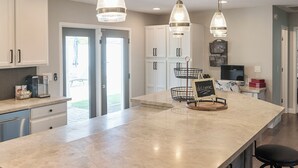A spacious kitchen with a large island, pendant lighting, and bar stools. - Old Town Scottsdale All around VACATION experience! Heated Pool & Media Room (Scottsdale)