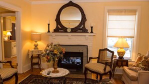 A cozy living room with a fireplace, a television, and comfortable seating. - Stay-cation In Charmified Village Guest House! (Aurora)