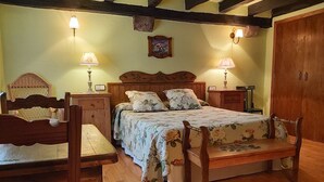 A traditional bedroom with a wooden bed, bedside tables, and a bench. - Labakizarra House for 8 people (Baztan)