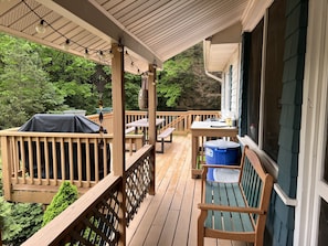 Enjoy a peaceful outdoor space with a bench and picnic table, surrounded by trees and a covered roof.