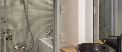A modern bathroom with a glass shower enclosure, a wooden bench, a large mirror, and a vessel sink.